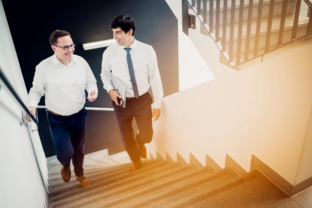 Zwei Rechtsanwälte gehen die Treppe hinauf
